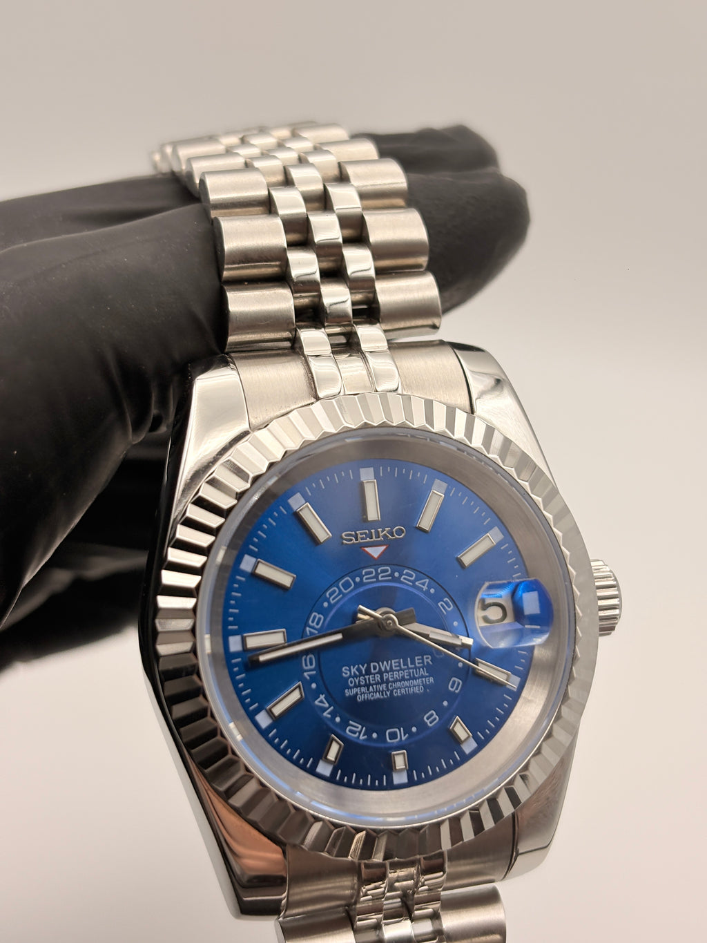 Silver Seiko watch with blue dial on a gray background