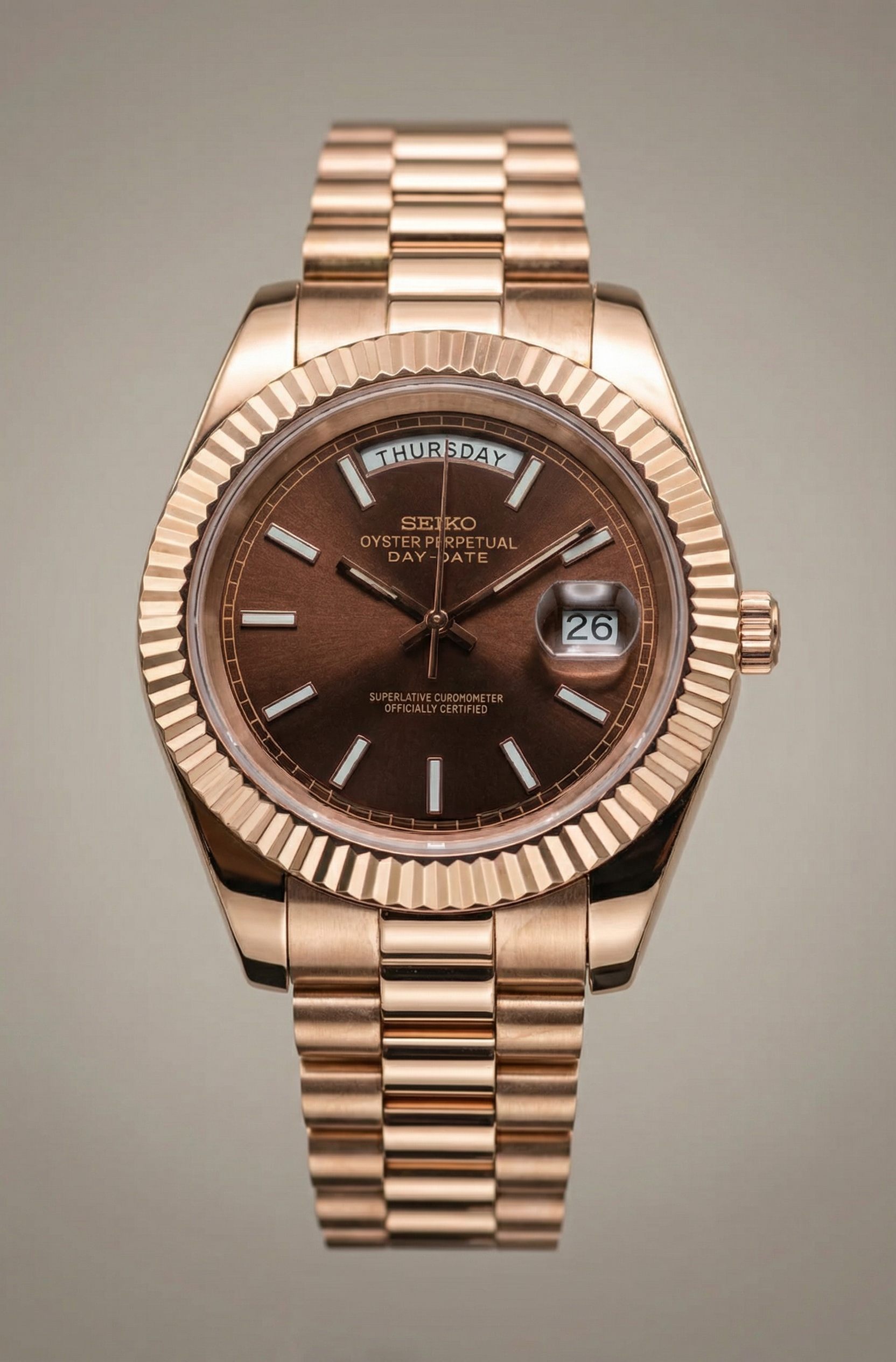 Rose gold Seiko watch with a brown dial on a gray background