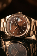 Rose gold watch with a reflective surface on a dark background